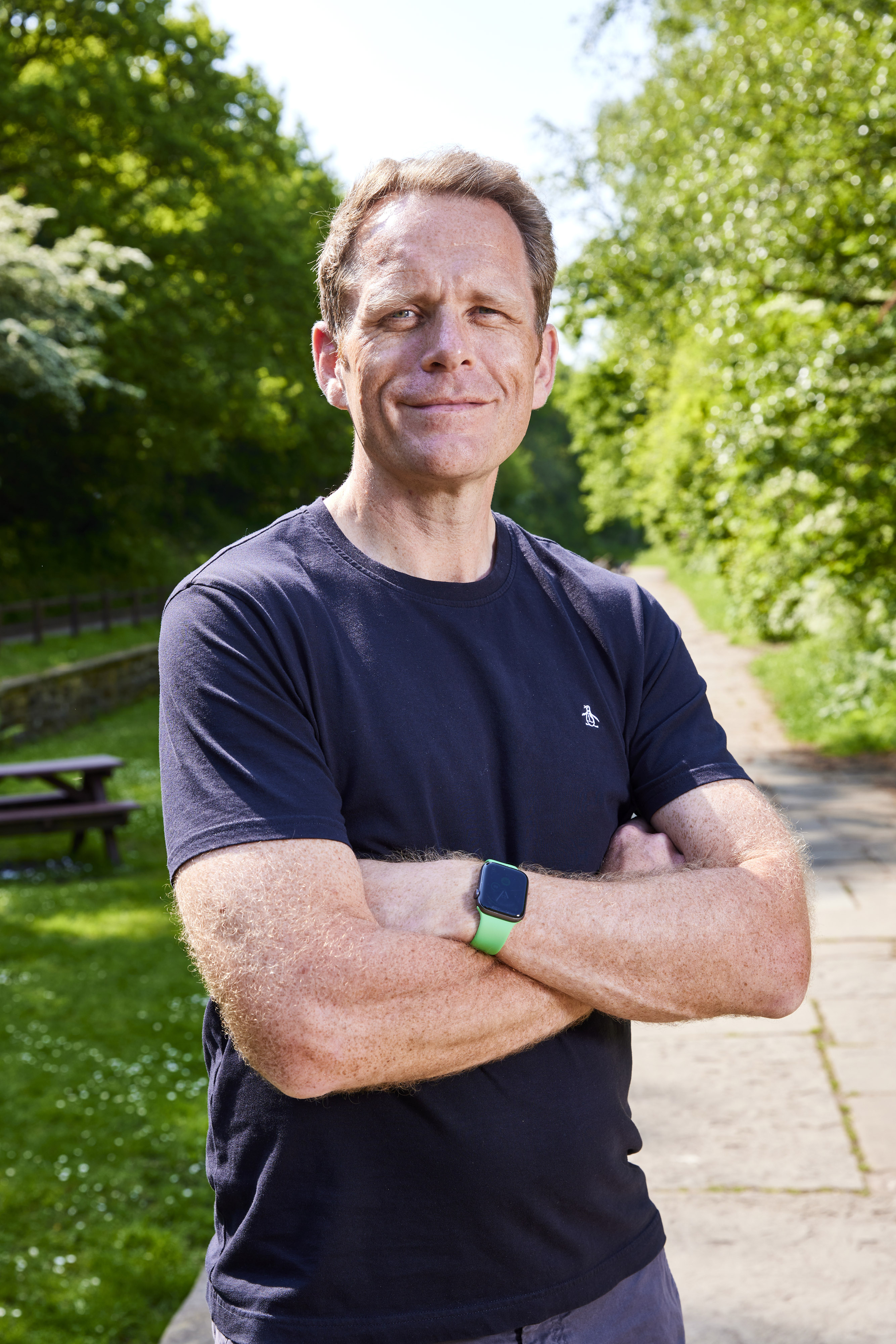 Al Kenny standing outdoors in a sunlit garden