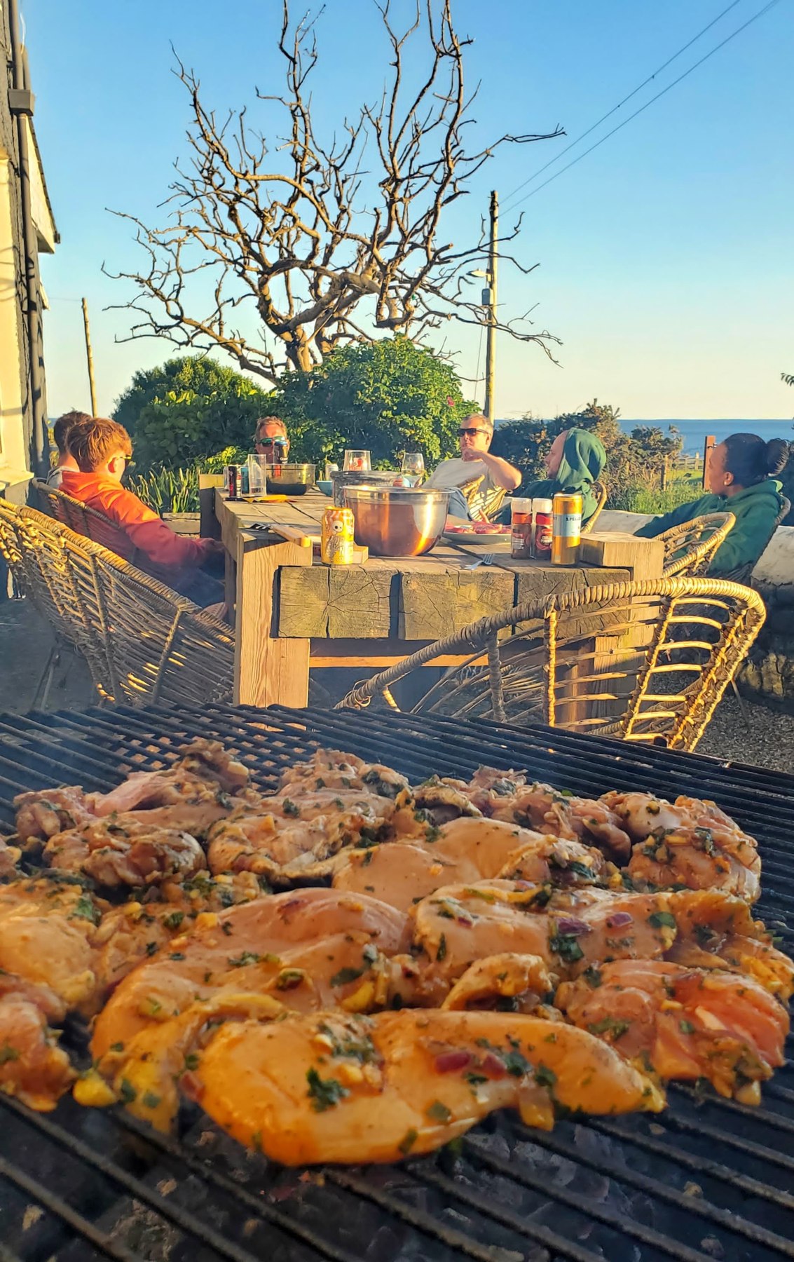 Food cooking outdoors at a past retreat, with a table set for a shared meal
